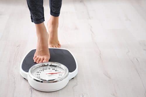 Woman checking weight using scale