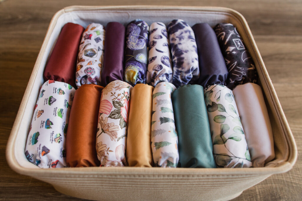 A Stack of Modern Neutral-Colored Reusable Cloth Diapers with a Neutral Background in Bright Natural Light